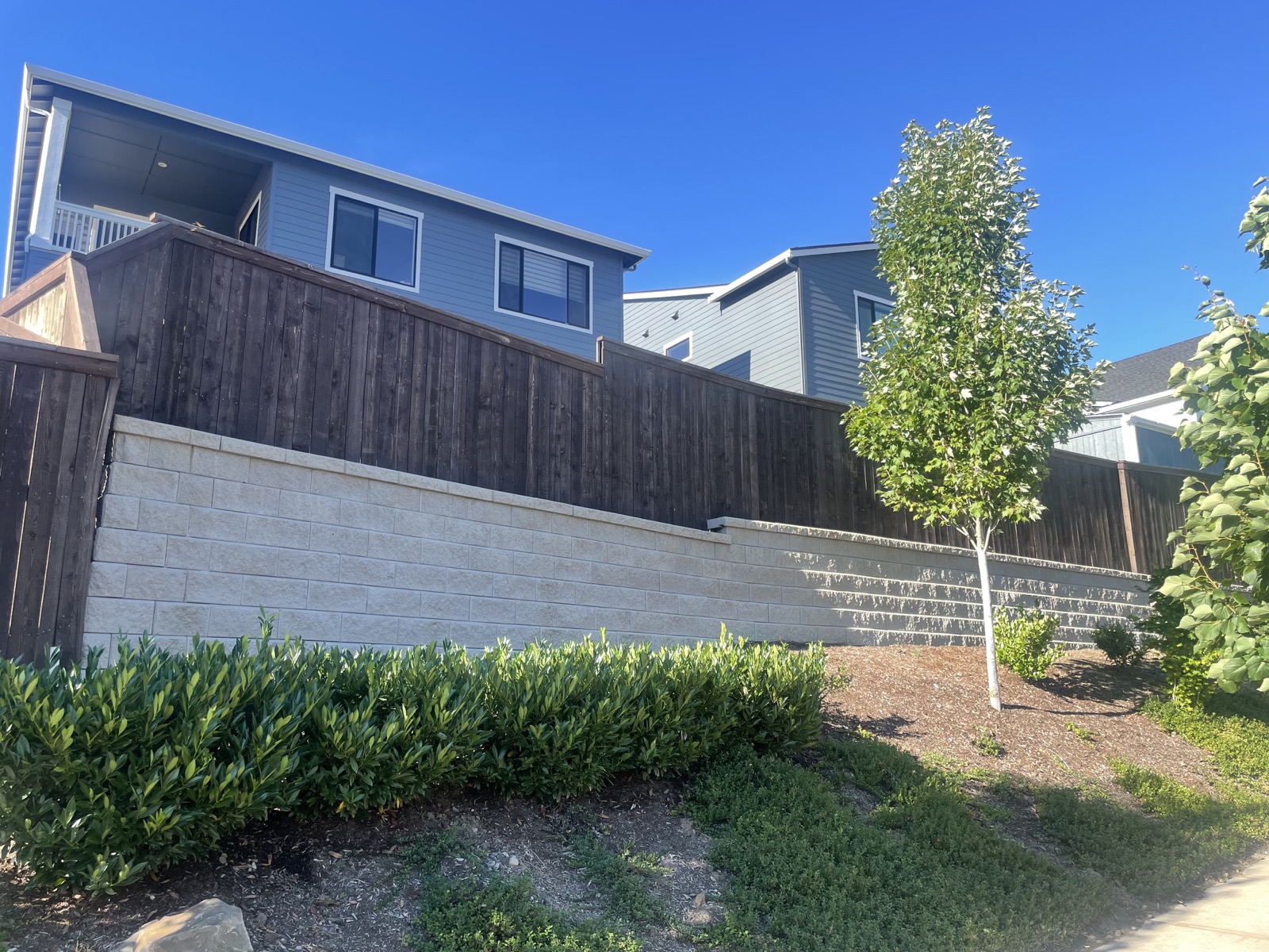 Wood privacy fence running along a landscaped residential property